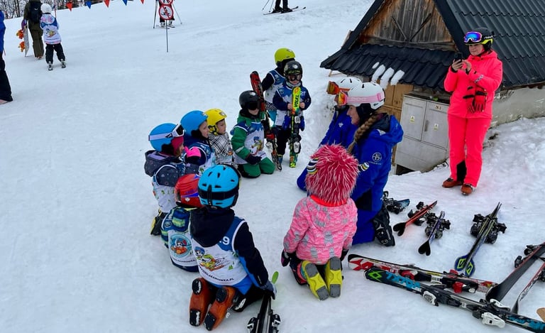 a group of children and adults in skis and snow gear
