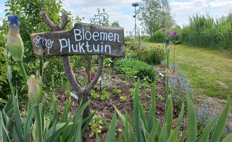 Welkomstbord van hout in de bloementuin van hortus populus
