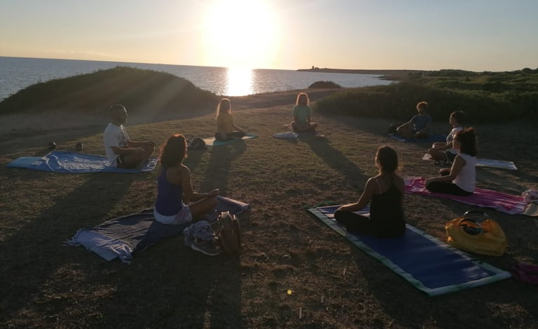 a group of people doing yoga on a beach