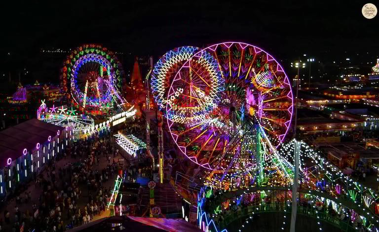 Night aerial view of Kota Dussehra Mela with glowing giant wheels, dazzling rides, and illuminated stalls.