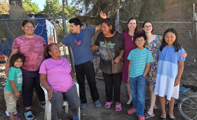 A diverse group of smiling community members and volunteers posing together outdoors.