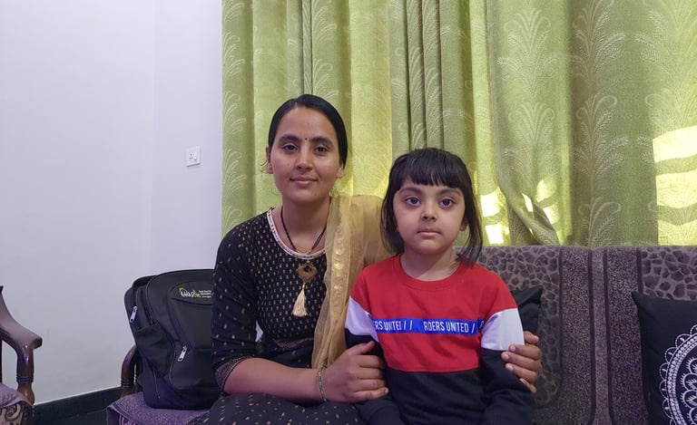 a woman sitting on a couch with her daughter