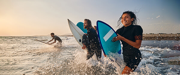 a mixed group surfing at sunset