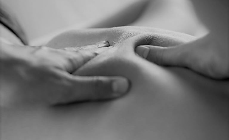 des mains massent un dos