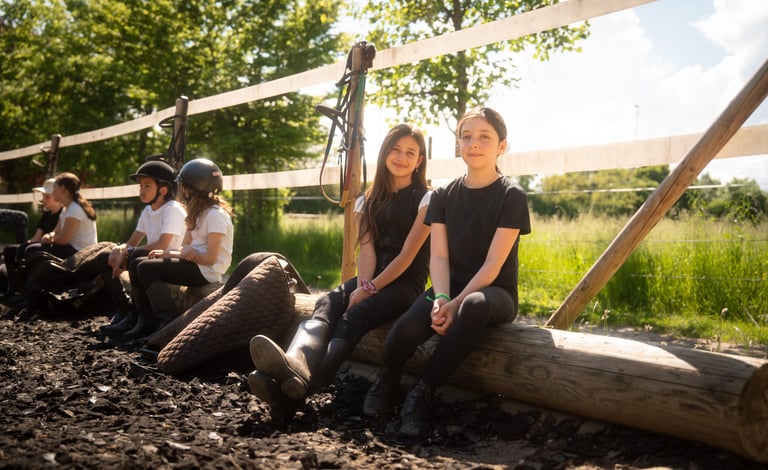 a group of kids sitting in horse ranch