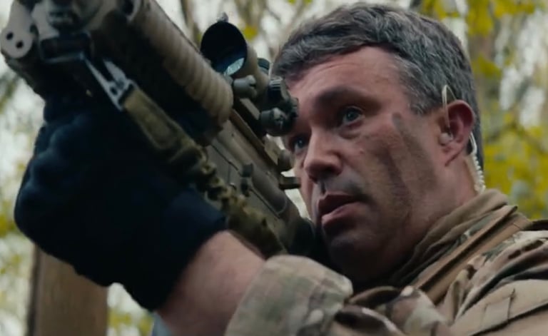 James Yeates Actor in a dramatic scene holding a prop weapon, showcasing action and military-style