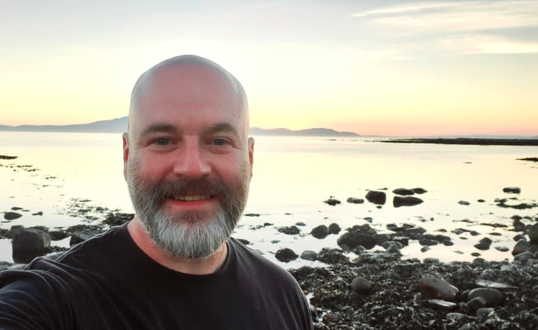 📝 Photo of Life First Then Work founder Andy standing by the sea at sunset