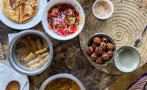 Visitors cooking and tasting traditional Zanzibari local dishes during a cooking class on a Zanzibar spice tour
