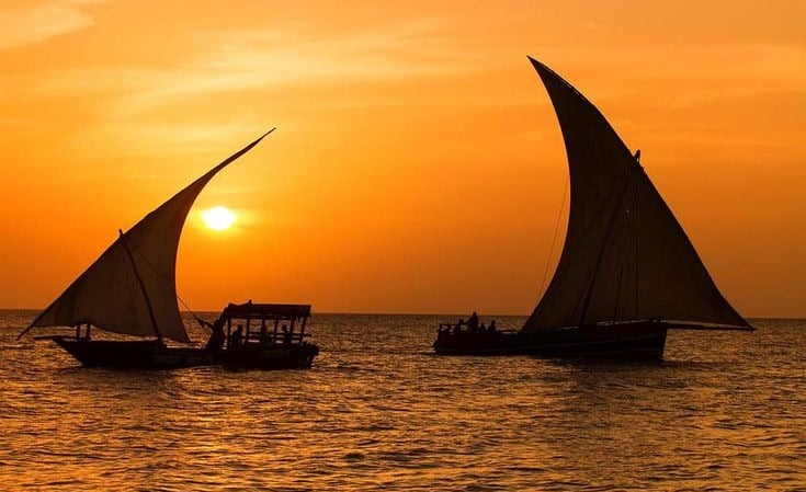Romantic sunset views aboard a classic Zanzibar dhow cruise, with golden skies and calm waters.