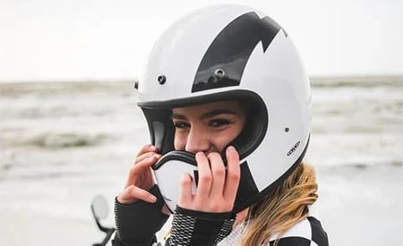 Piękna motocyklistka na plaży w kasku DMD Racer Flash