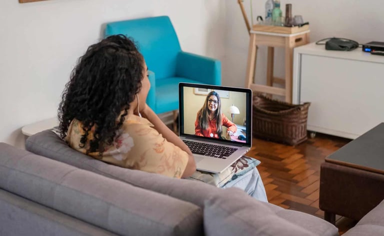 a woman sitting on a couch with a laptop computer