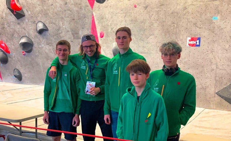 a group of people standing around a climbing wall