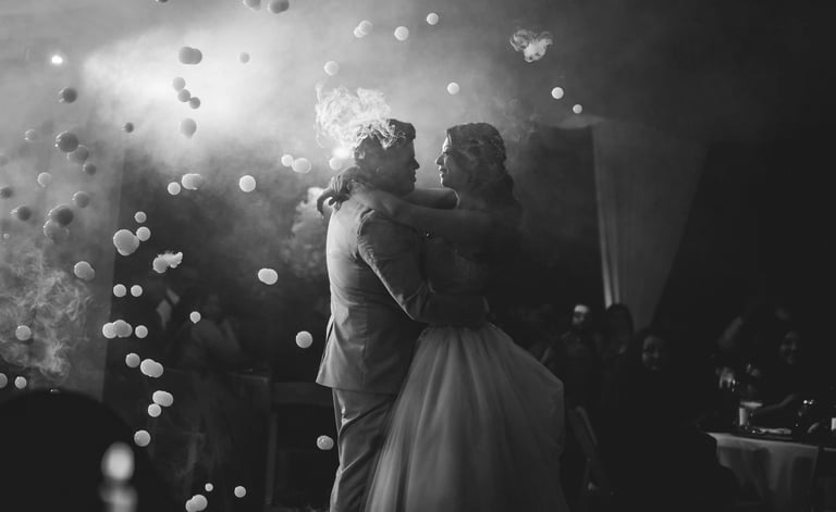 a bride and groom share a kiss at their wedding reception