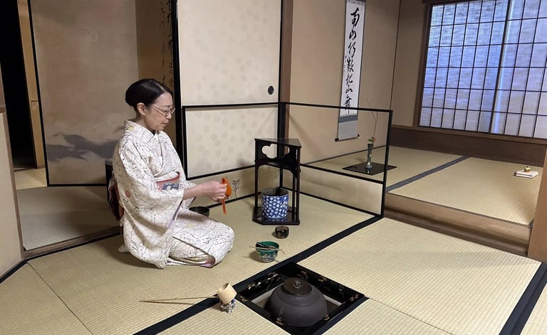 Japanese tea ceremony master sitting in seiza position in a traditional tatami room preparing matcha