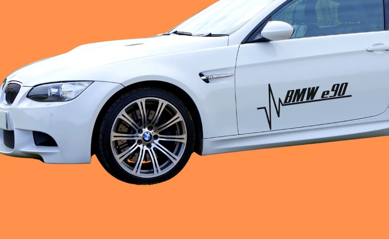 White BMW E90 M3 coupe with black heartbeat decal on orange background