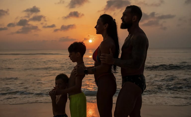 Family silhouette at sunset on Dreamland Beach Bali with parents holding their son during a golden hour family photography 