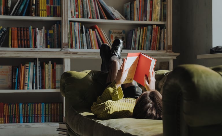 A girl reading on the sofa in her library