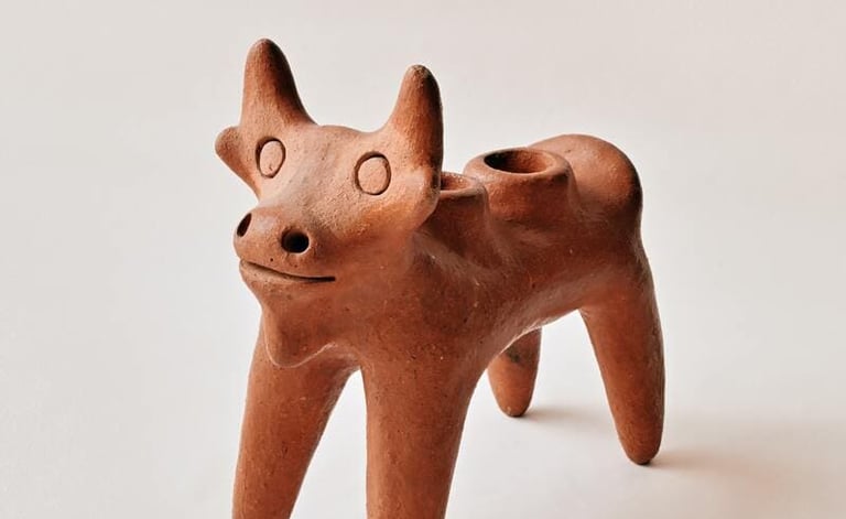 Figurilla artesanal de vaca elaborada en barro terracota, con acabado rústico en tono café y diseño.