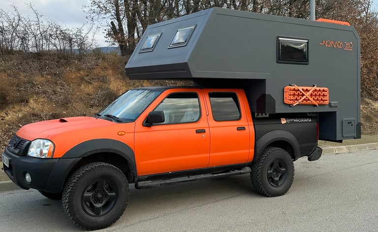 vehículo pick up de color naranja con cabina vivienda