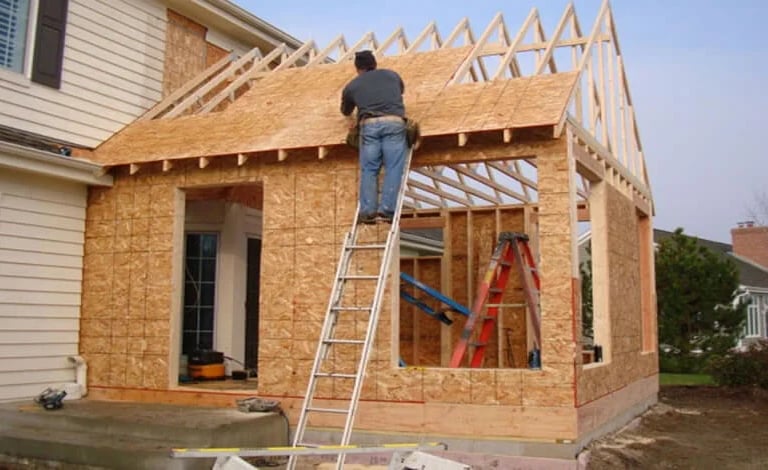 a man is standing on a ladder to get a roof