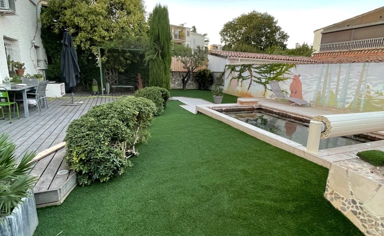 Aménagement de jardin avec gazon synthétique et terrasse bois réalisé par paysagiste à Montpellier