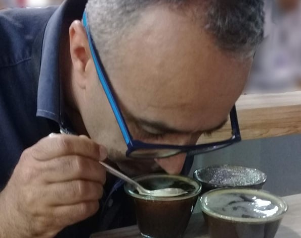 a man in glasses and a blue shirt is eating a meal