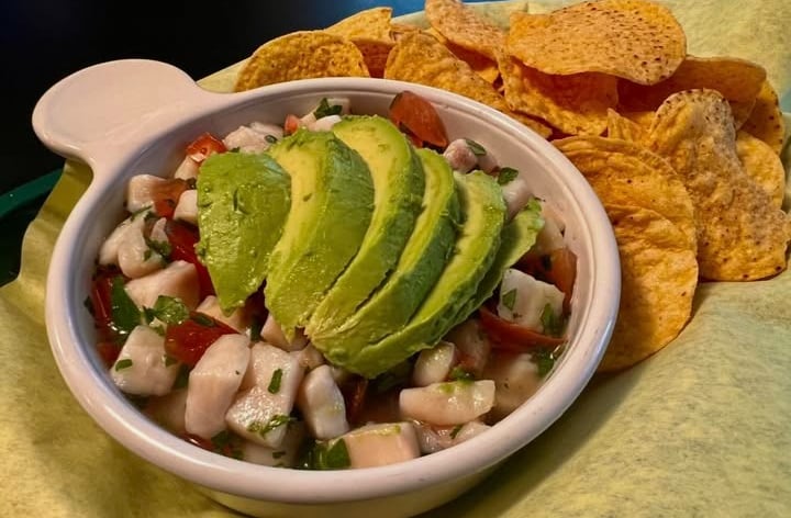 Ceviche served with lime, avocado and herbs