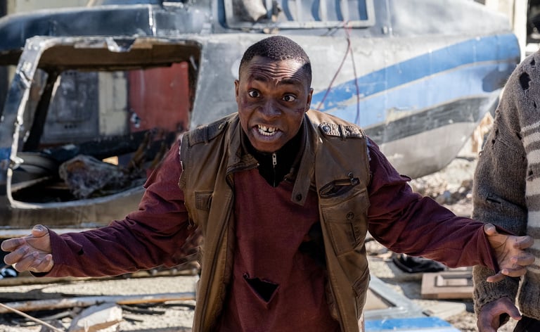 Actor dressed as a zombie leaning forward and staring straight at camera with arms wide open