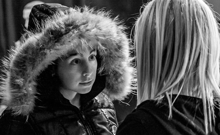 Two young ladies facing each other deep is discussion about a dance performance issue
