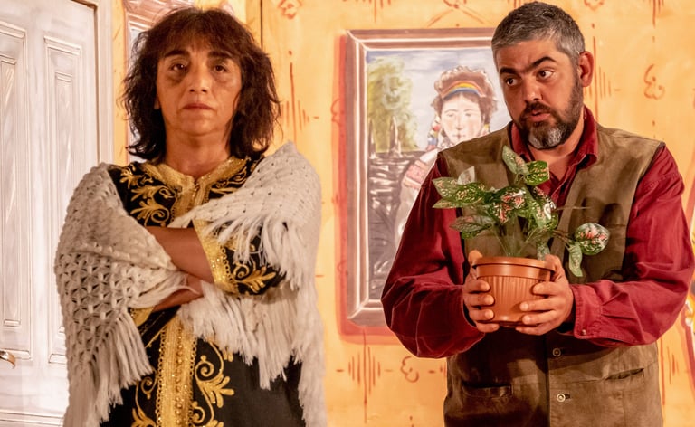 Two actors one holding out a plant to the other as peace offiering
