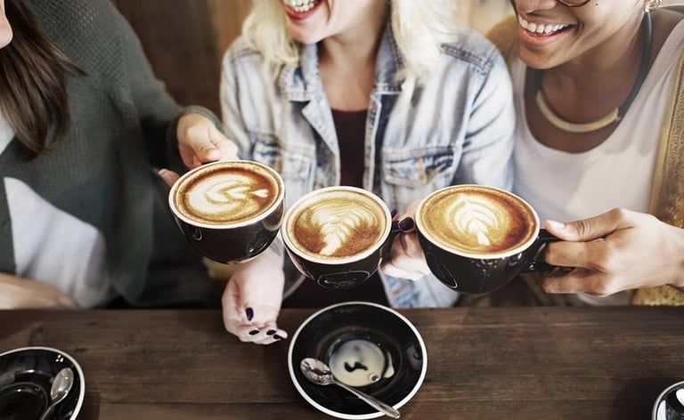 a group of people sitting at a table with coffee cups