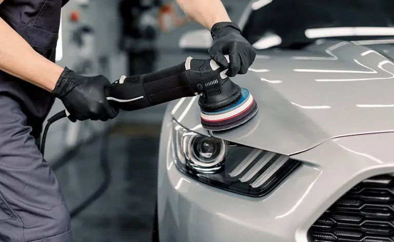 a man in a uniform polishing a car
