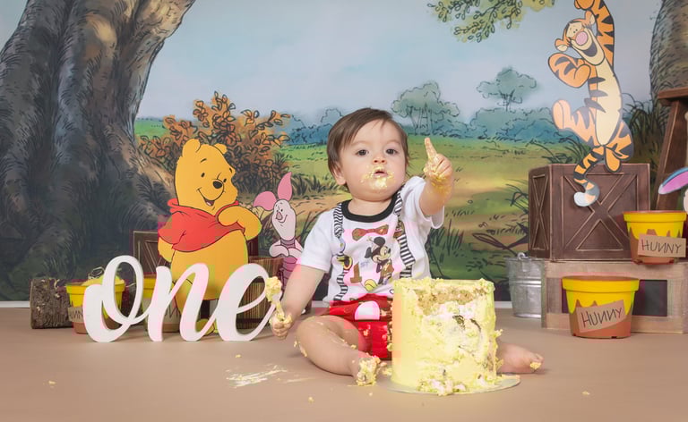 a baby girl in a pink dress and pink balloons