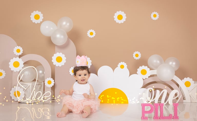 two babies are sitting on a table with balloons and balloons