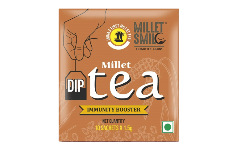 Box of millet tea with a hand holding a tea bag