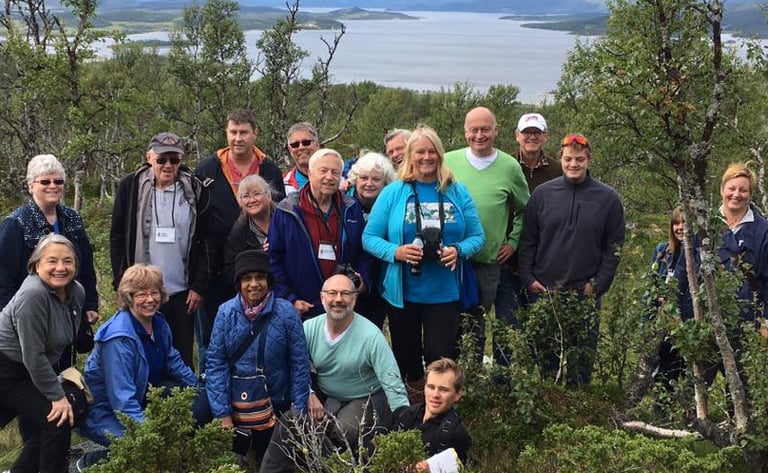 a group of Telelaget members at the top of a hill in norway overlooking a lake