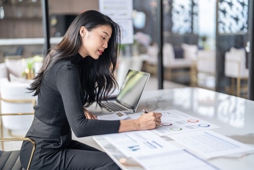 a woman sitting at a table with a laptop 
