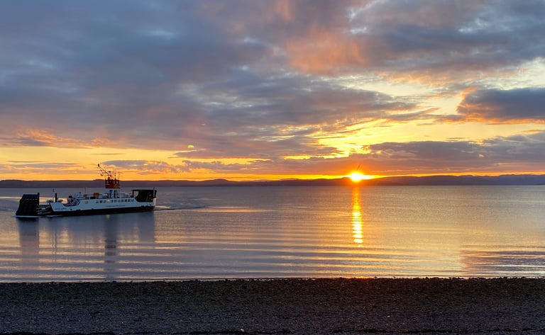 Largs bay at sunset with the ferry to Cumbrae coming in to land