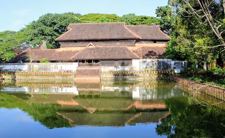 Rear view of Krishnapuram Palace in Kerala with a serene pond in the foreground.