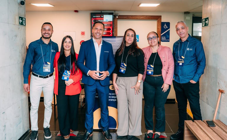 Group of business professionals posing at a corporate event seminar in a hallway.
