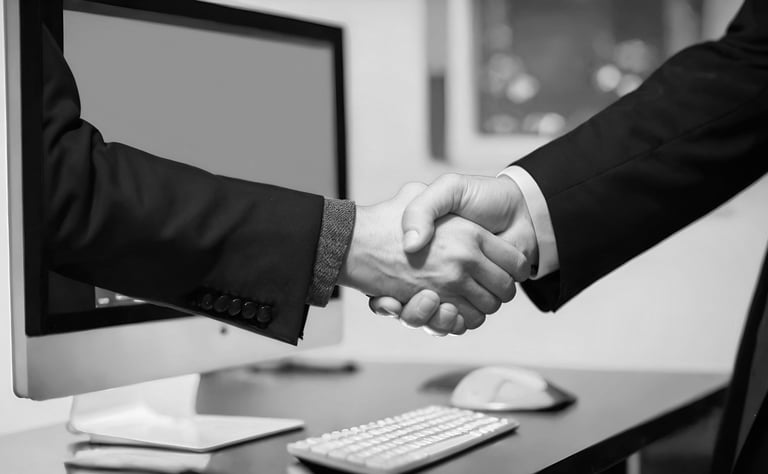people shaking hands in front of a computer
