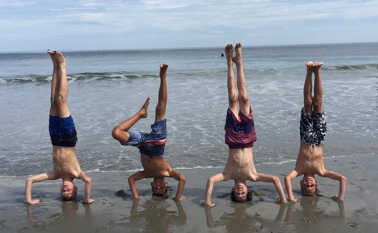 4 boys doing headstands on the beach in Rye, New Hamsphire