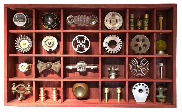 Wood box with 24 metal objects placed in 24 niches.