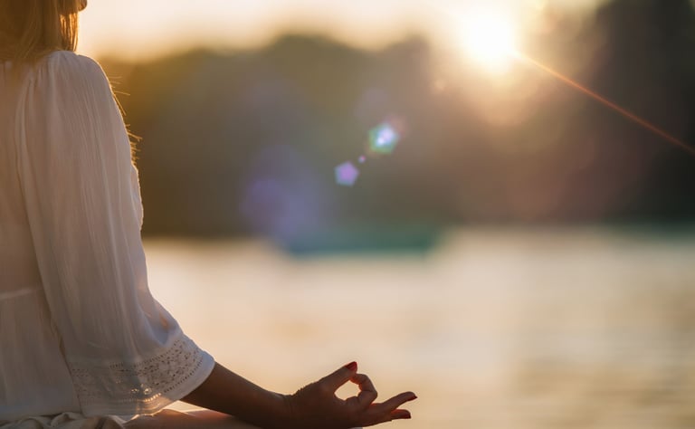 “Femme en méditation au bord de l’eau au coucher du soleil, posture de relaxation et bien-être.”