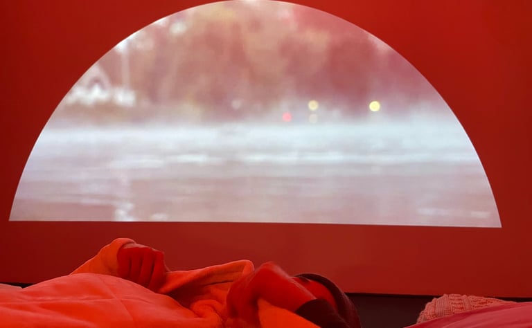 Une personne allongée dans un lit, avec un lac thermique projeté derrière.