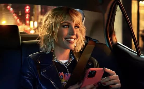 a woman in a leather jacket and a cell phone