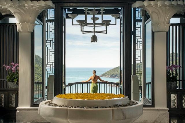 A lady overlooking a wellness resort bay from the lobby