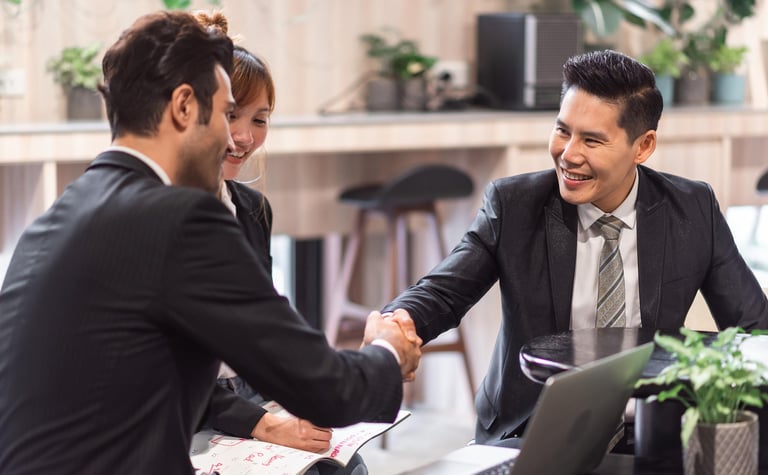 Karyawan berjabat tangan saat menerima apresiasi dalam sistem reward.