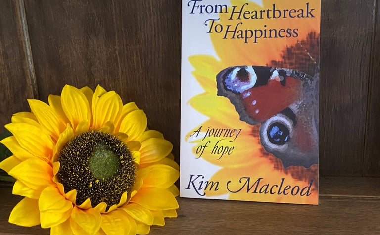 From Heartbreak to Happiness Book on a shelf next to a sunflower