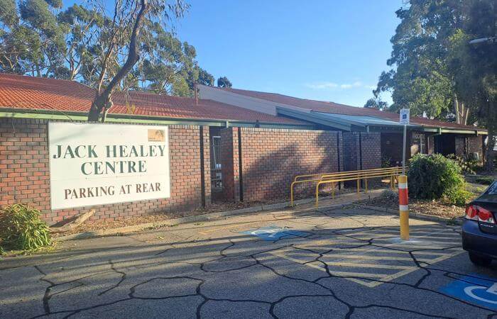 a parking lot with a car parked in front of Jack Healey Centre
